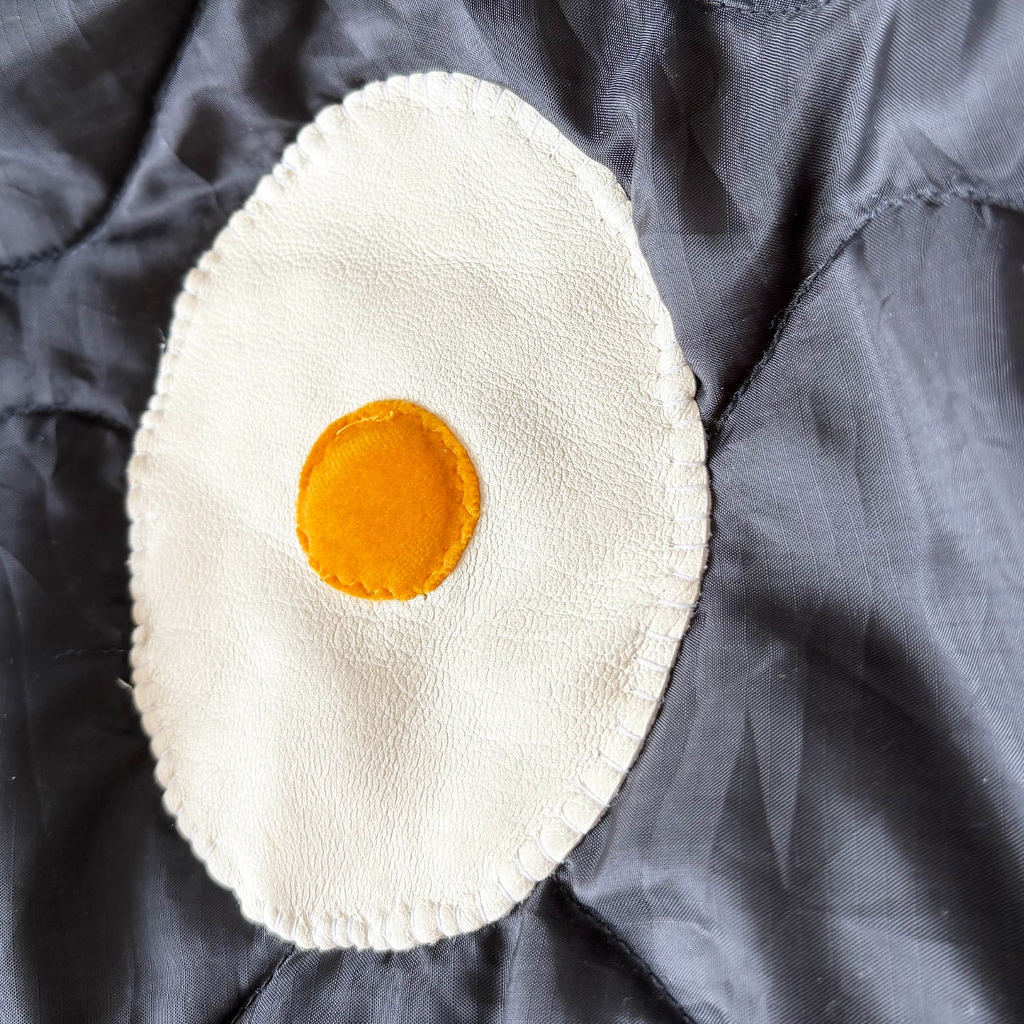 Leather fried egg patch with velvet yoke.