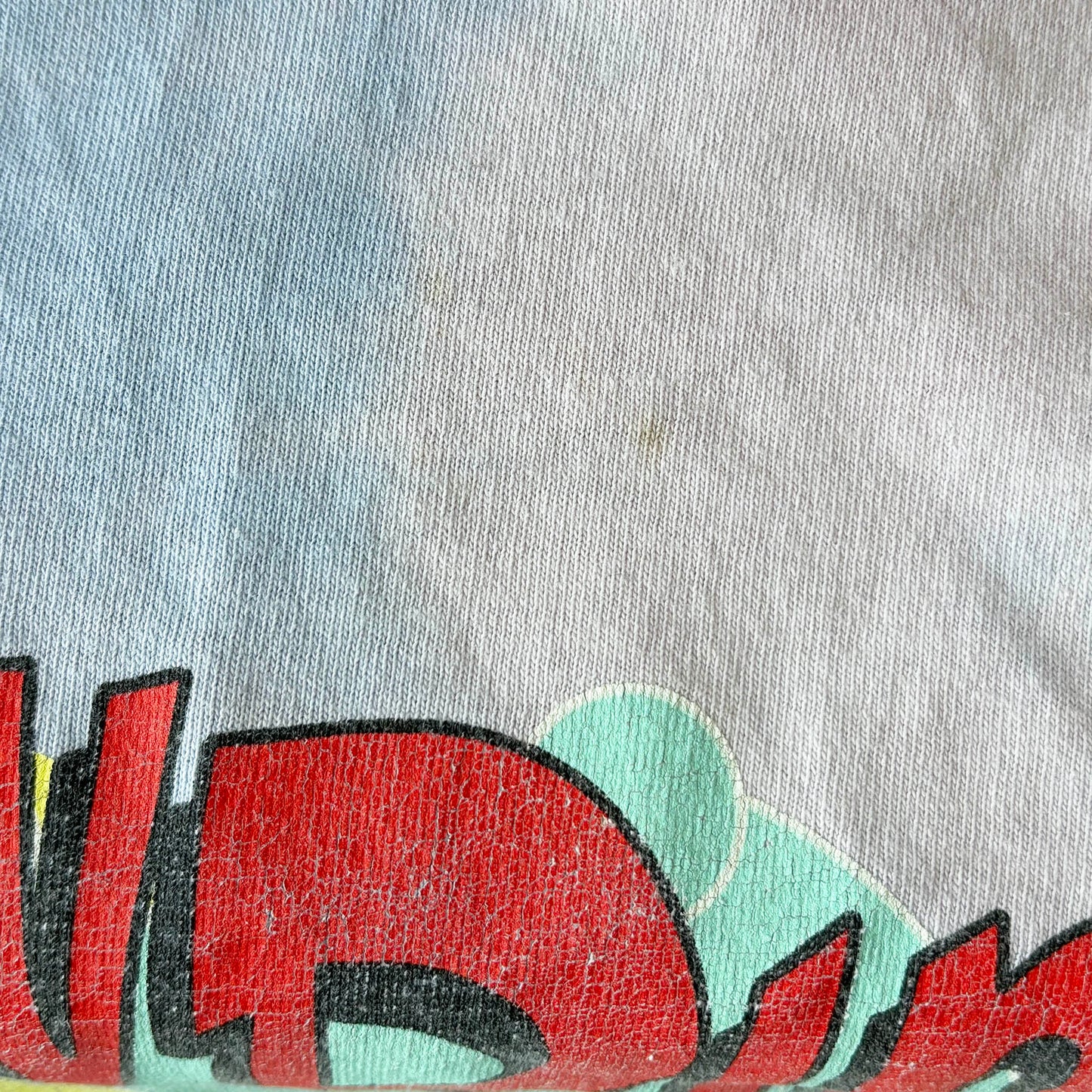 Close-up of very small very light stain a gray fabric with colorful graphic design
