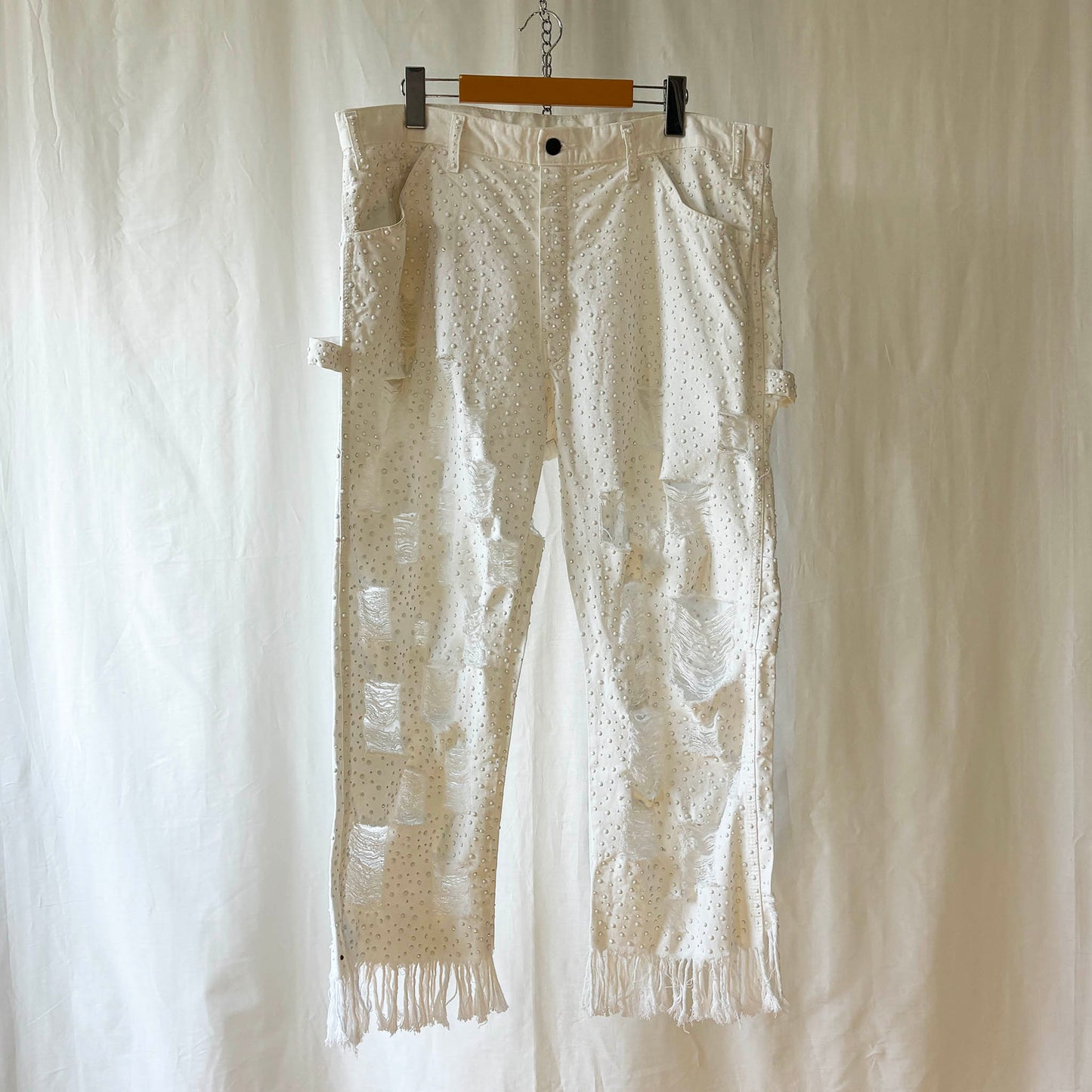 white pants with window pane distressing and completely stoned with 4 sizes of flat white rhinestones. 