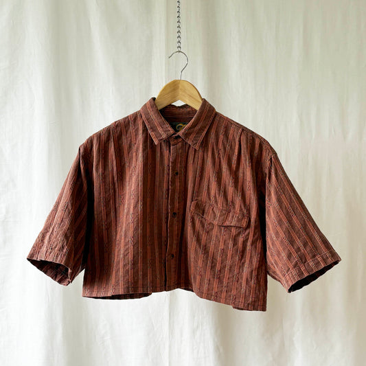 Orange striped shirt on a hanger against a white background