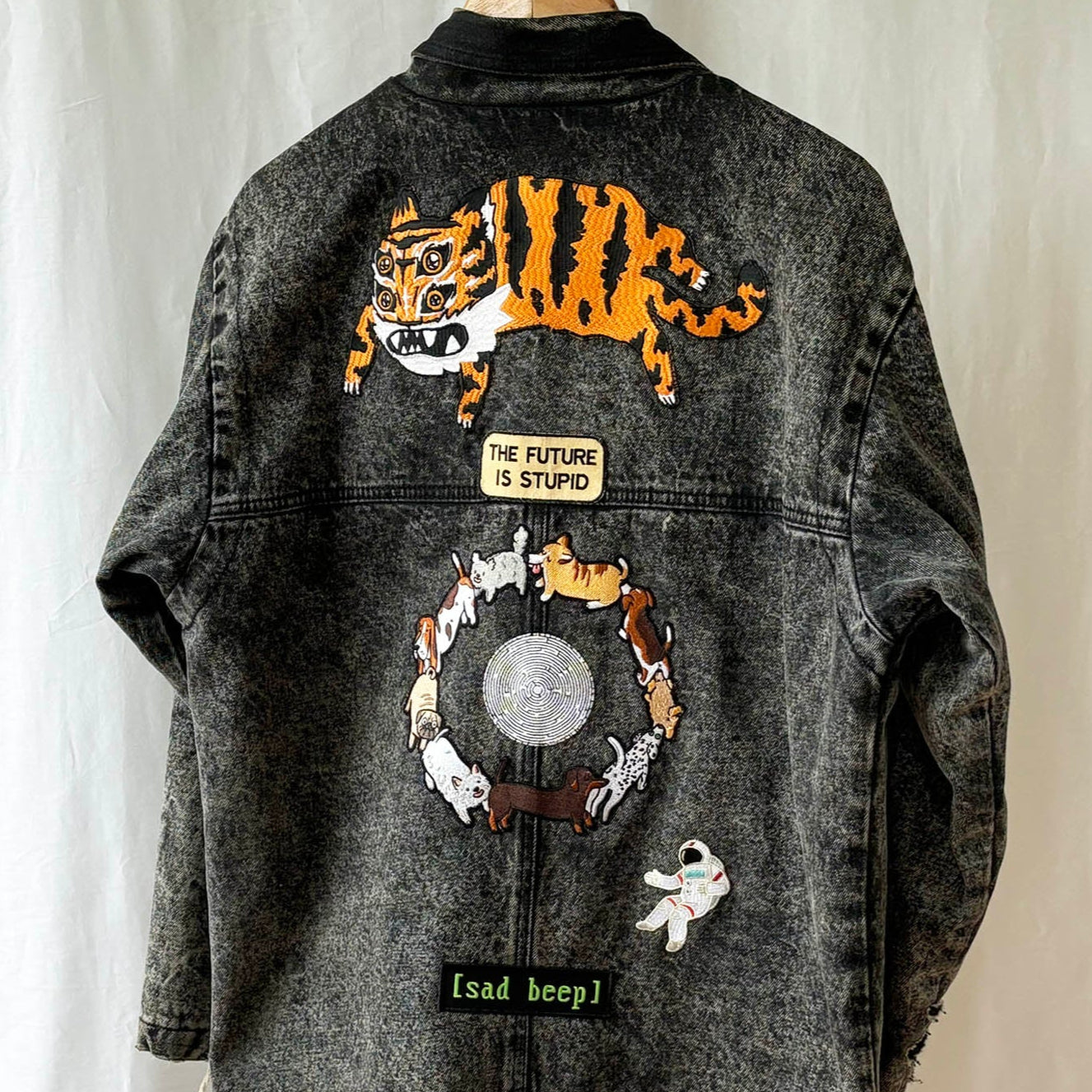 Denim jacket with embroidered designs on a white background
