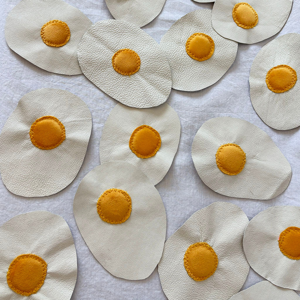 leather eggs with velvet yokes arranged on a white surface.