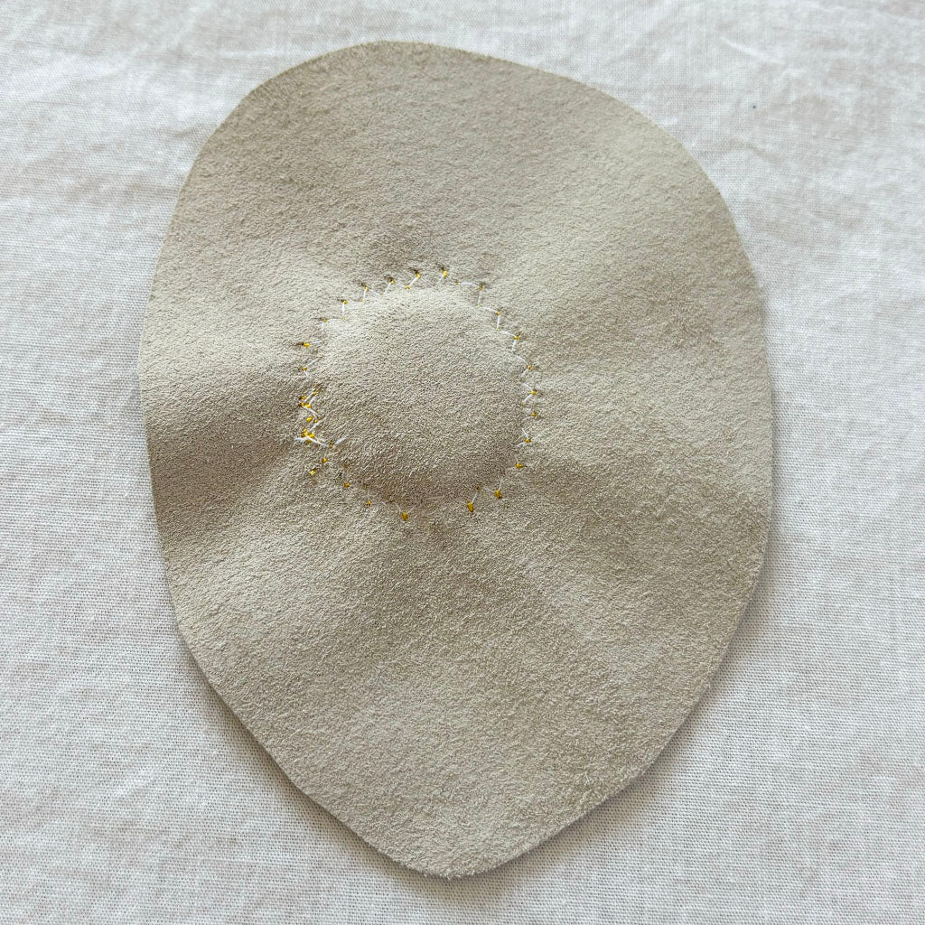 leather back with circular zigzag stitching.