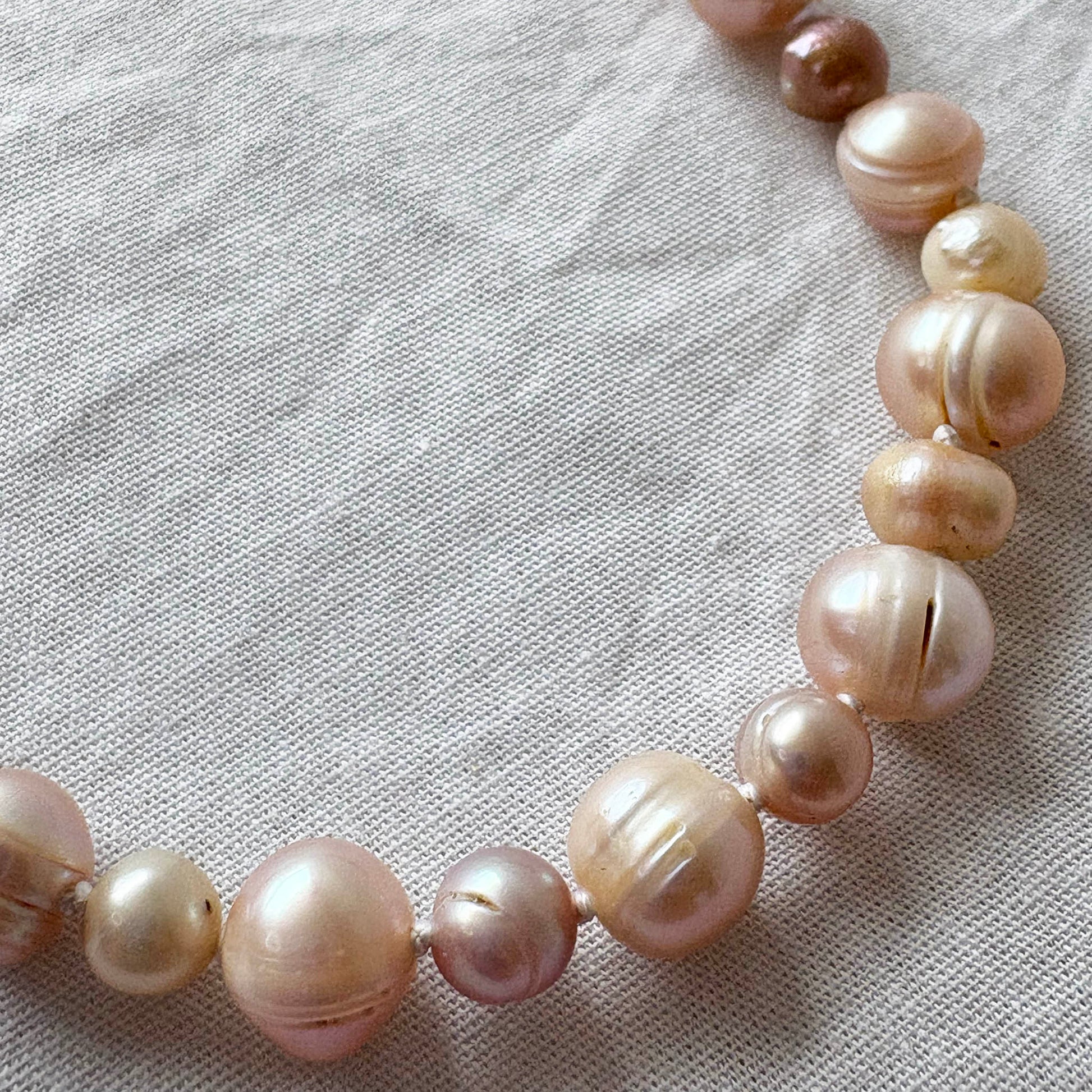 Pearl necklace on a textured fabric background