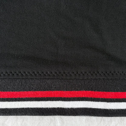 Close-up of reattached hem. hem has red and white stripes on a textured surface