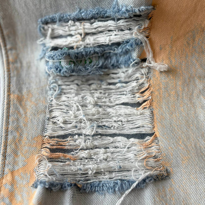 Distressed denim square with peach paint.