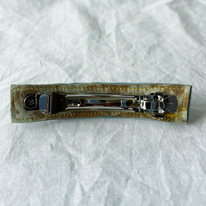 Metallic hair clip on a textured white background